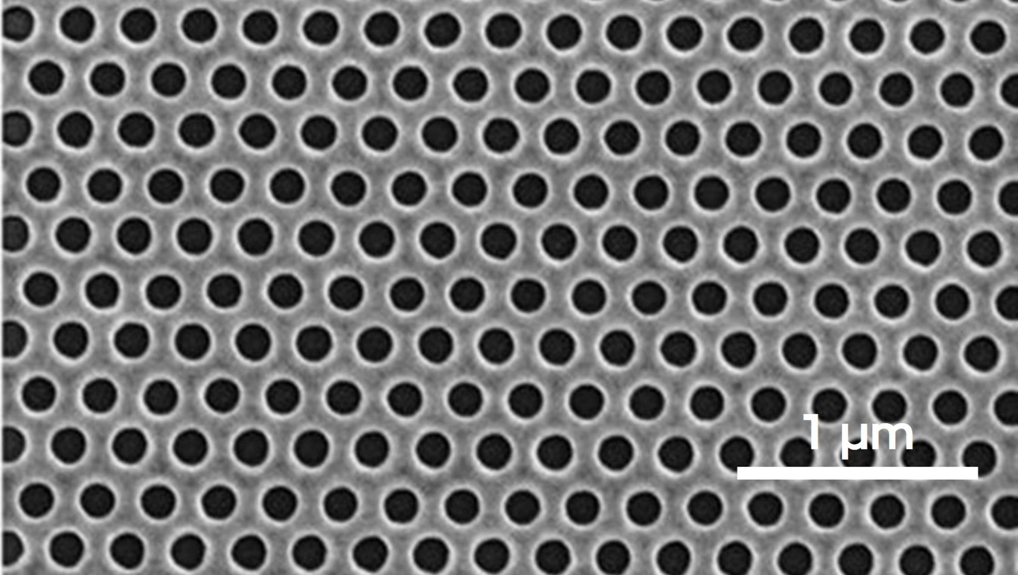 Scanning electron microscope image showing a regular array of submicron aluminum nanoholes for optical applications such as structural colors.